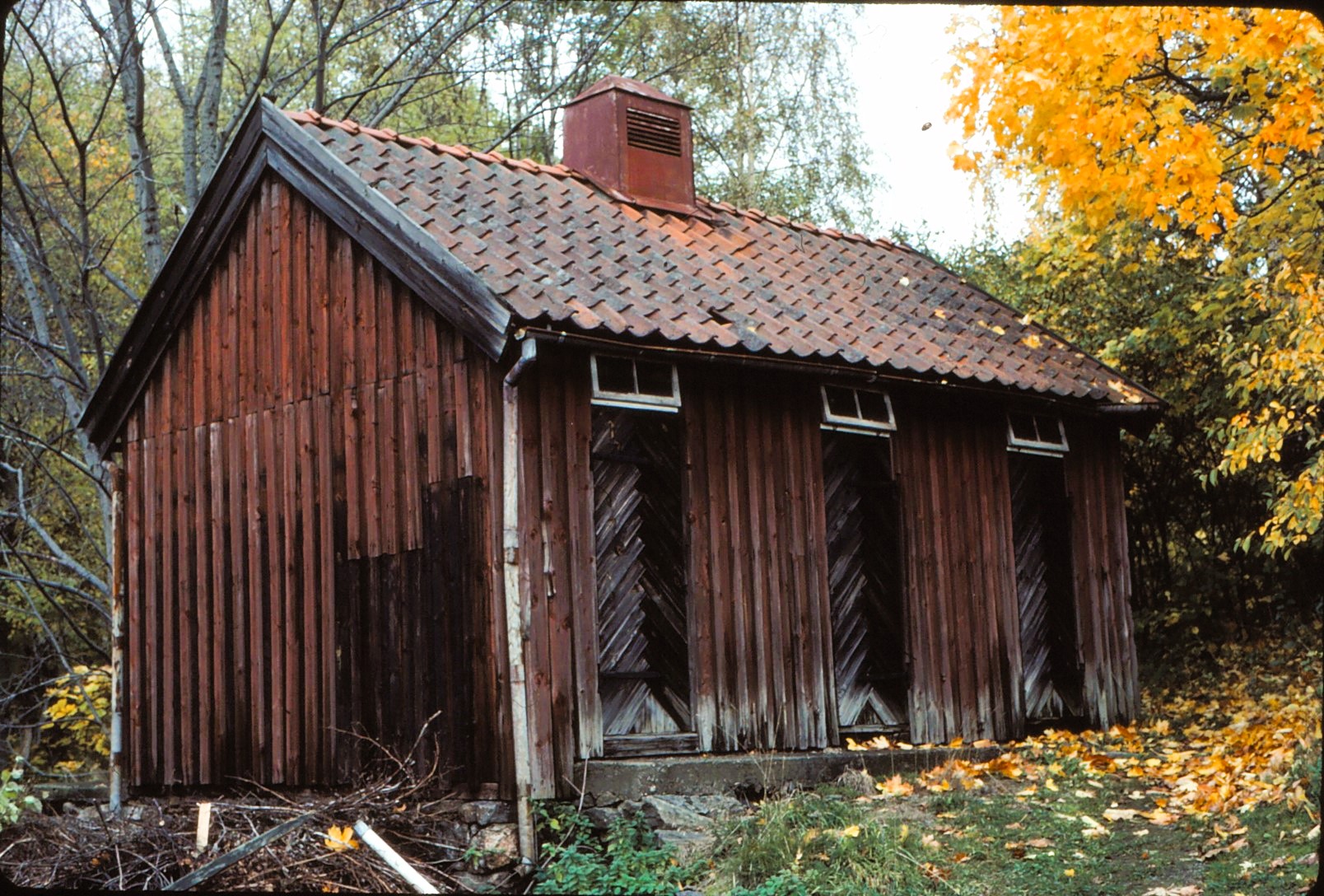 Äldre, mindre träbyggnad med tre dörrar